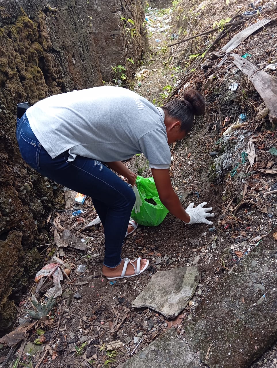 Niños llenando botellas con tierra para plantar árboles en el jardín escolar