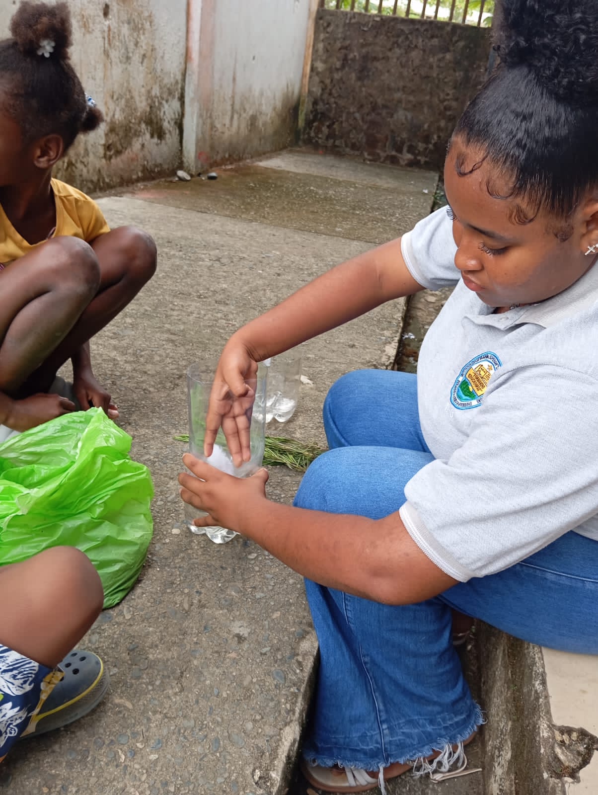 Niños regando los árboles recién plantados en botellas recicladas