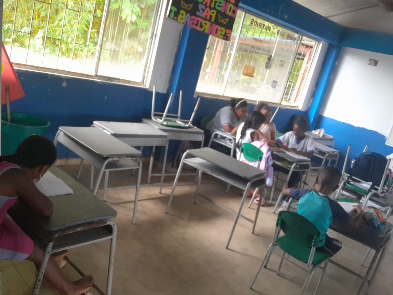 Niños escribiendo en cuadernos durante una actividad en el salón de clases