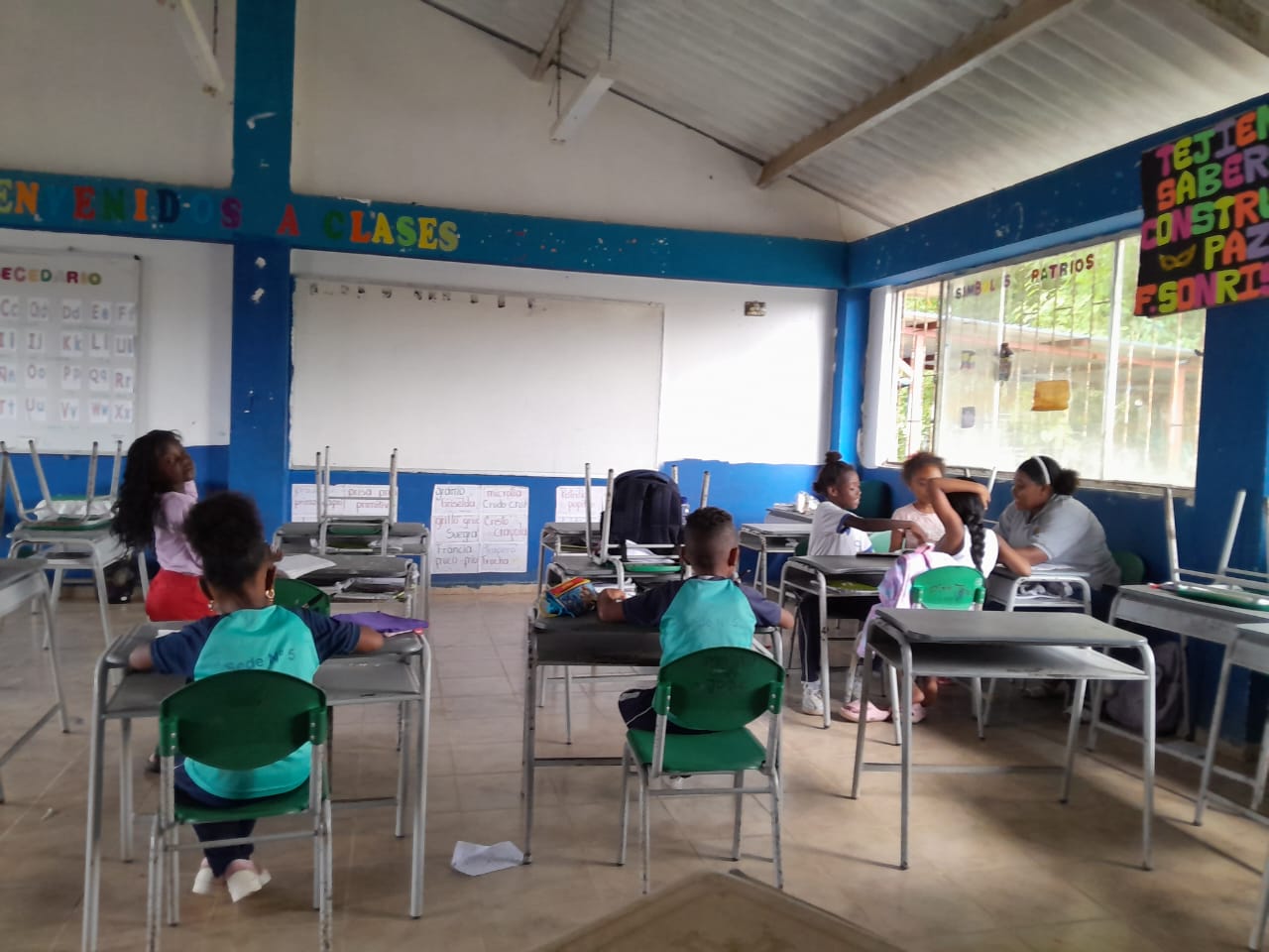 Estudiantes trabajando en grupo con cartulinas en el aula