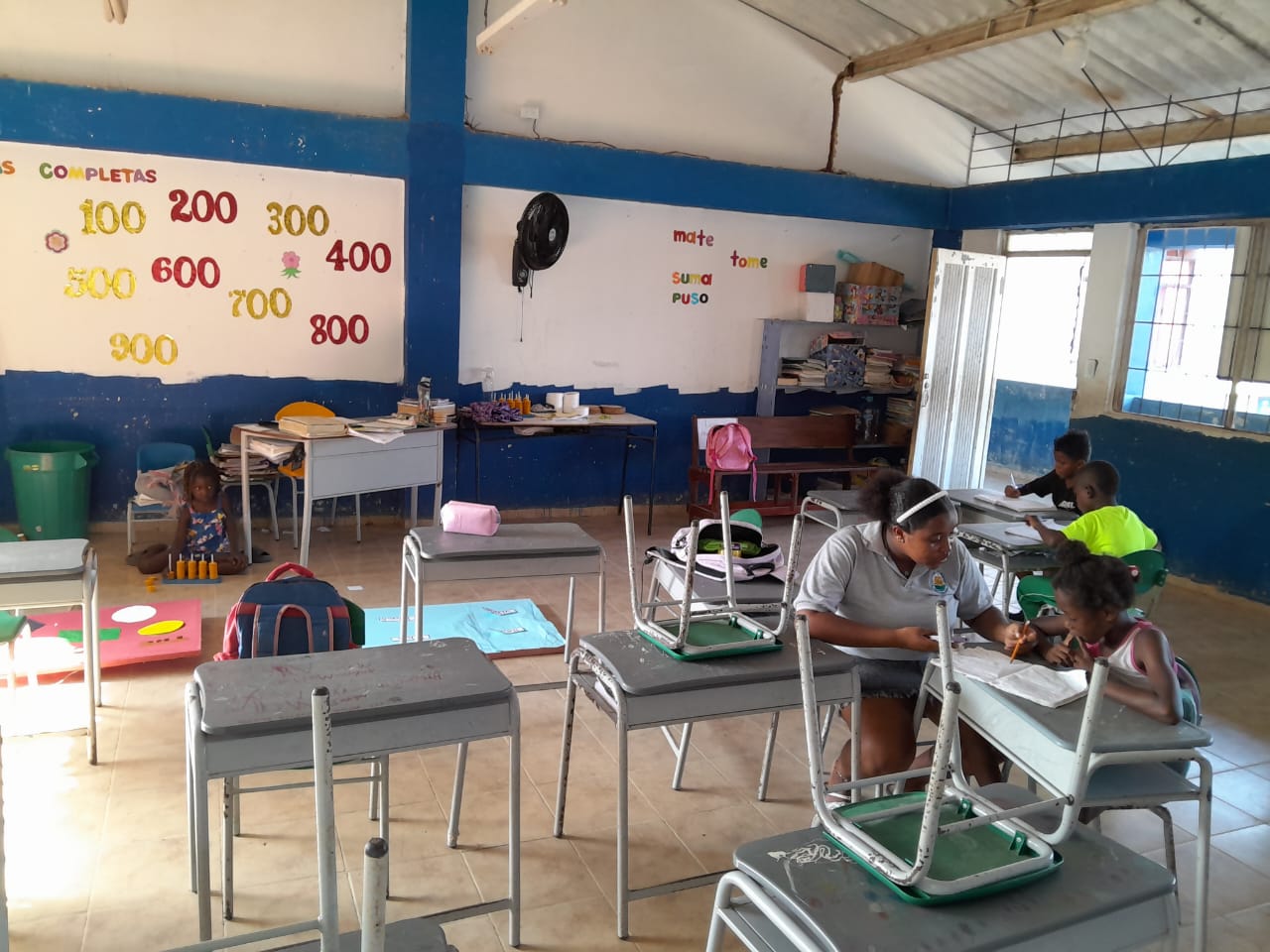 Estudiantes presentando su trabajo en cartulinas frente a la clase